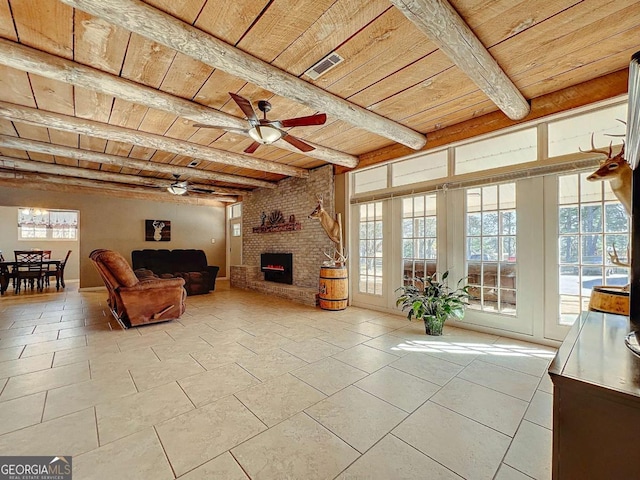 living room featuring beamed ceiling, plenty of natural light, a brick fireplace, and wooden ceiling