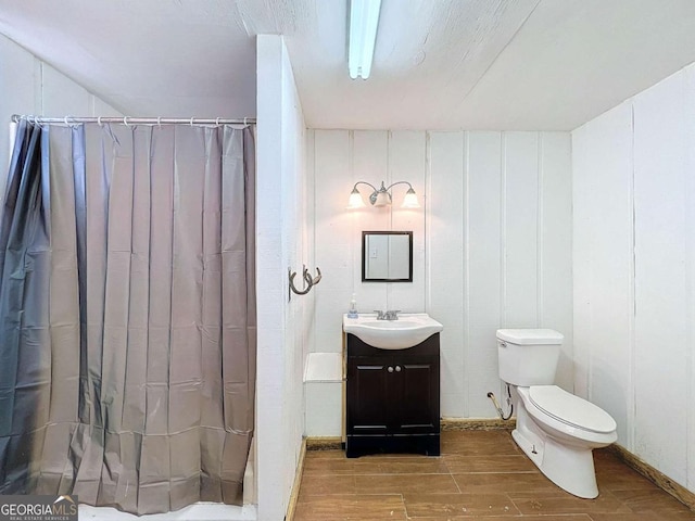 bathroom featuring vanity, toilet, and curtained shower