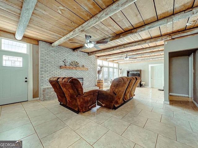 tiled living room featuring ceiling fan, a wealth of natural light, wooden ceiling, and beam ceiling