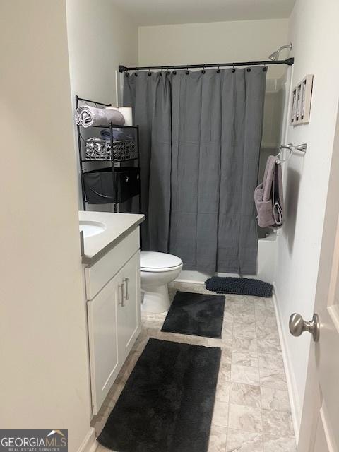 bathroom featuring vanity, curtained shower, and toilet