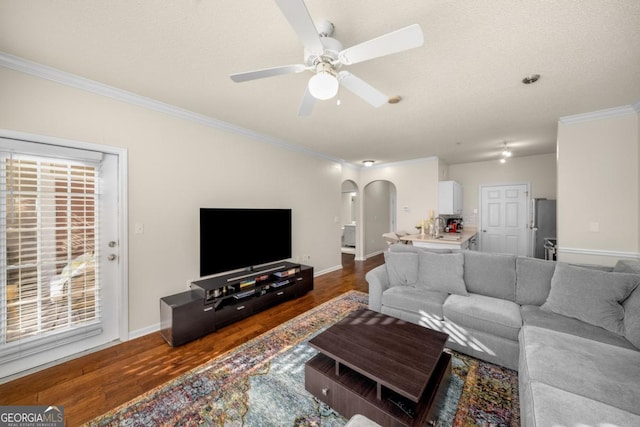 living room with ornamental molding, dark hardwood / wood-style floors, and ceiling fan