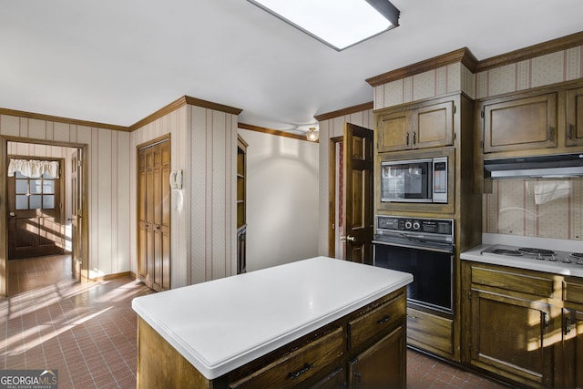 kitchen featuring wallpapered walls, a kitchen island, built in microwave, and black oven