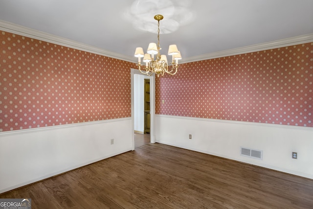 empty room with a wainscoted wall, ornamental molding, and visible vents