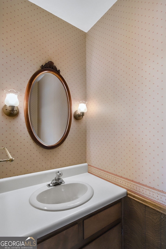 bathroom featuring vanity and wallpapered walls