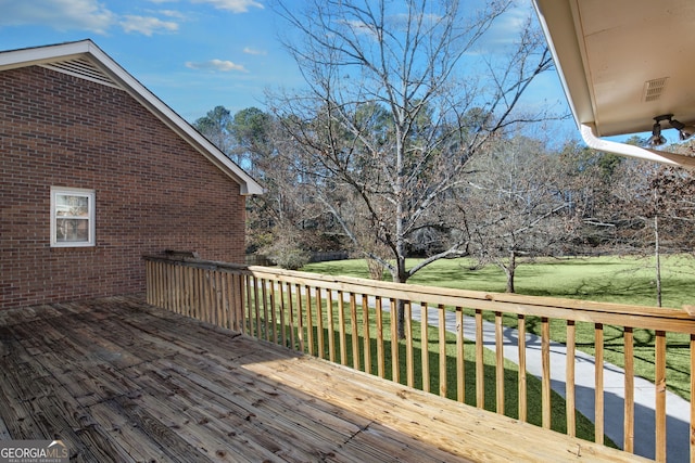 wooden terrace featuring a yard