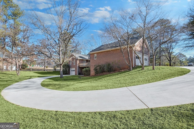 view of home's exterior featuring a garage, driveway, a lawn, a residential view, and brick siding