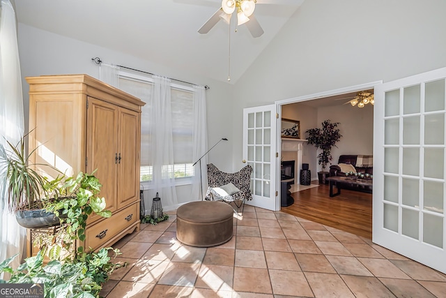 living area featuring light tile patterned flooring, high vaulted ceiling, ceiling fan, and french doors