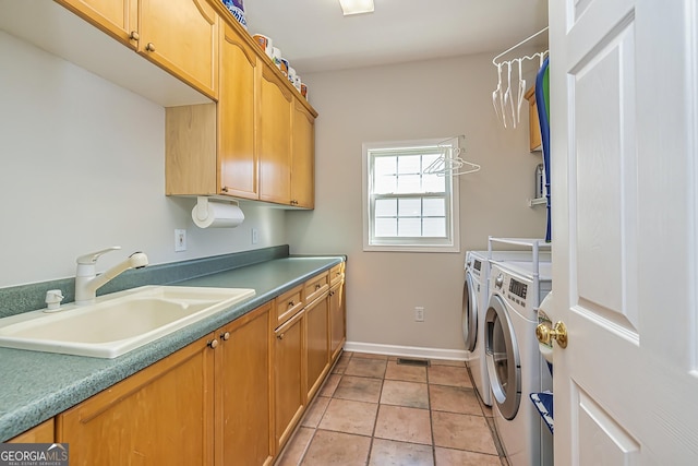 laundry area featuring cabinets, separate washer and dryer, sink, and light tile patterned floors