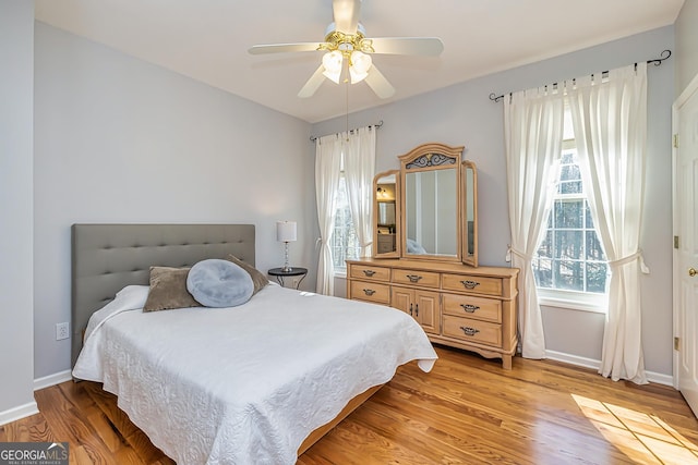 bedroom featuring multiple windows, ceiling fan, and light hardwood / wood-style flooring