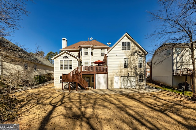 back of house featuring a garage and a deck