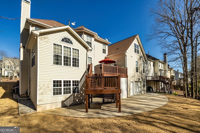 back of house with a deck and a patio area