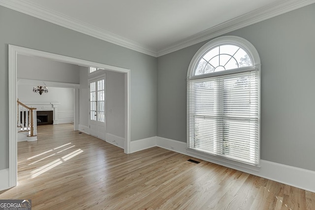 spare room with ornamental molding and light hardwood / wood-style floors