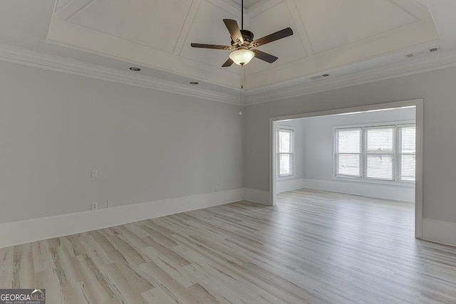 spare room with light hardwood / wood-style floors, ornamental molding, a raised ceiling, and ceiling fan