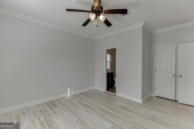 unfurnished bedroom featuring crown molding, ceiling fan, ensuite bathroom, light hardwood / wood-style floors, and a closet