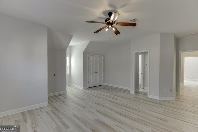 additional living space with ceiling fan, vaulted ceiling, and light wood-type flooring