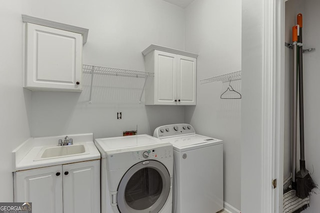 washroom with cabinets, sink, and washing machine and dryer