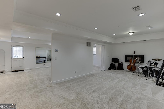 misc room with a tray ceiling, ornamental molding, and light colored carpet