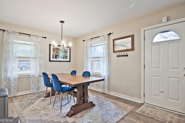 dining area with dark hardwood / wood-style floors and a notable chandelier