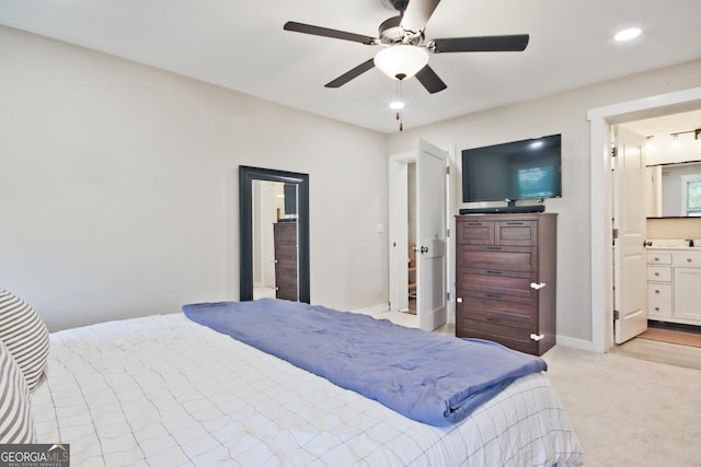 bedroom with light carpet, connected bathroom, and ceiling fan