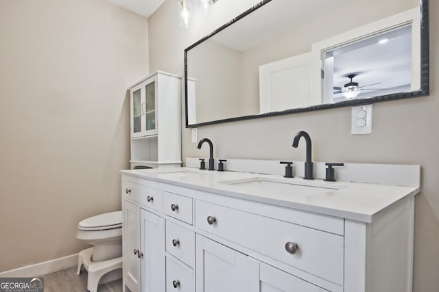 bathroom featuring vanity, ceiling fan, wood-type flooring, and toilet