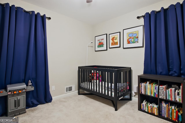 carpeted bedroom featuring a nursery area