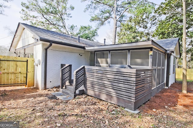 rear view of property featuring a sunroom