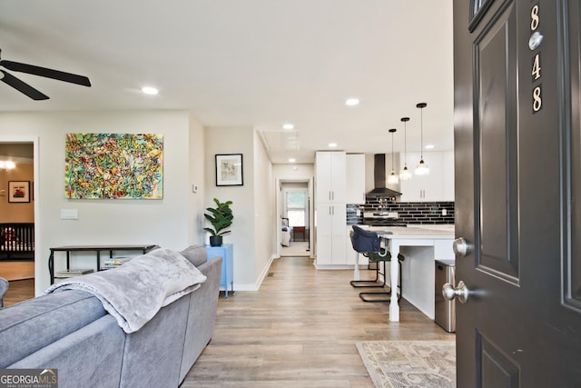 living room featuring ceiling fan and light hardwood / wood-style floors