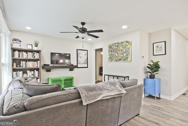 living room with ceiling fan and light hardwood / wood-style flooring