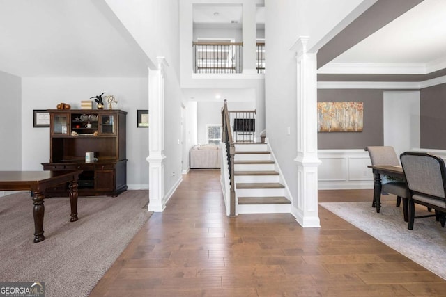 entryway with decorative columns, wood-type flooring, and crown molding