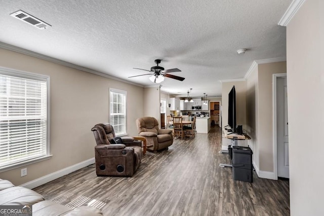 living room featuring ornamental molding, dark hardwood / wood-style floors, ceiling fan, and a textured ceiling