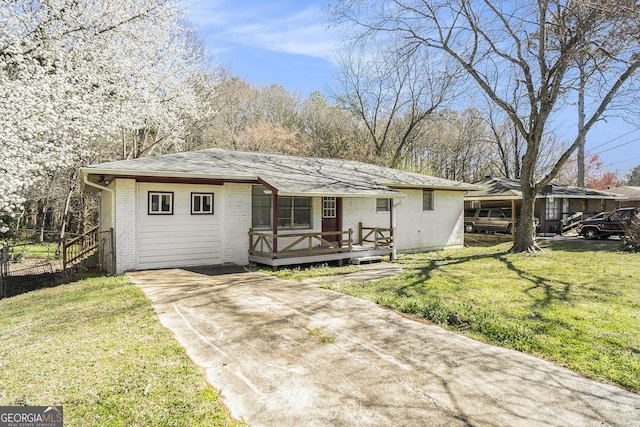 ranch-style house featuring a wooden deck, a front yard, and brick siding