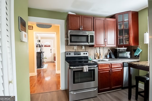 kitchen with tasteful backsplash, appliances with stainless steel finishes, and dark hardwood / wood-style floors