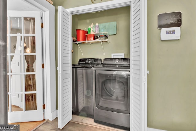 laundry area featuring hardwood / wood-style flooring and washing machine and clothes dryer