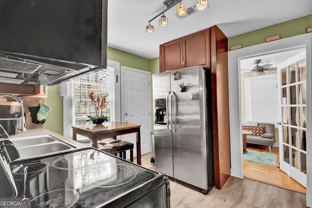 kitchen featuring sink, light hardwood / wood-style flooring, stainless steel fridge, ceiling fan, and range with electric cooktop