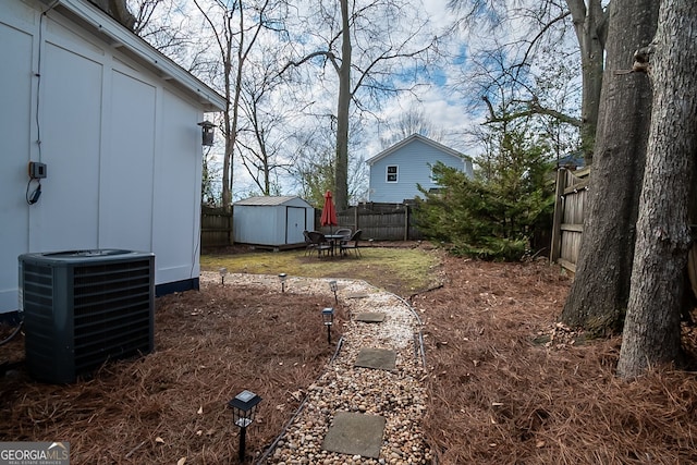 view of yard with cooling unit and a storage unit