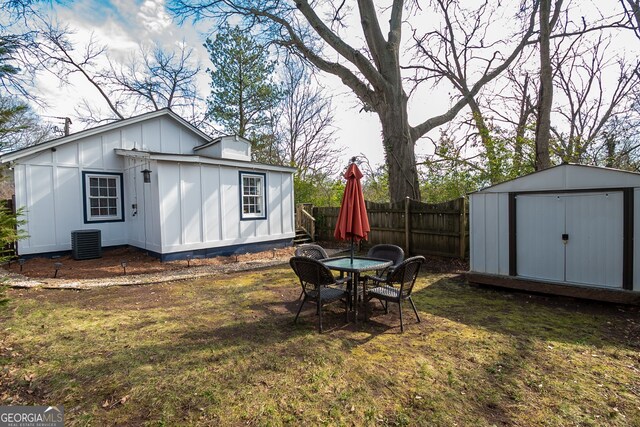 view of yard featuring central AC and a storage unit