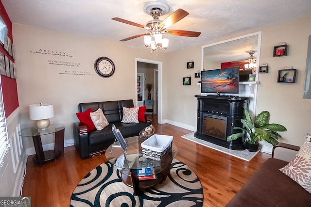 living room with ceiling fan, hardwood / wood-style flooring, and a textured ceiling