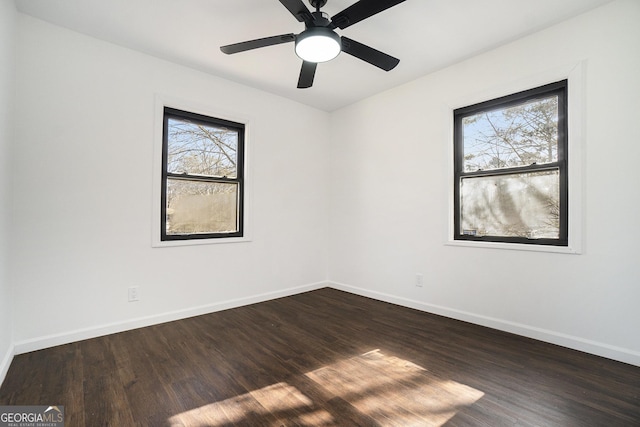 empty room featuring dark hardwood / wood-style flooring, ceiling fan, and a healthy amount of sunlight