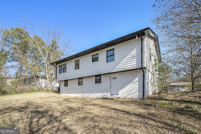 rear view of house featuring a lawn