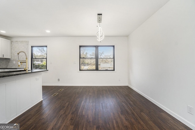 unfurnished dining area featuring dark hardwood / wood-style flooring