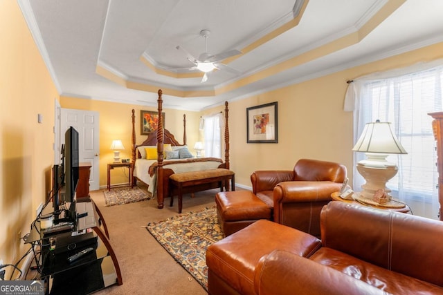 carpeted bedroom featuring crown molding, ceiling fan, and a tray ceiling