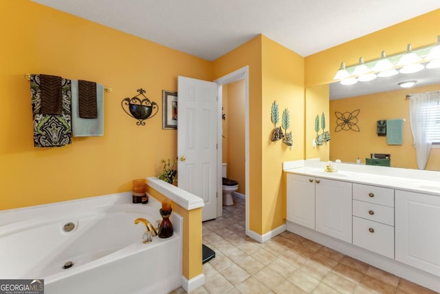 bathroom featuring vanity, a tub to relax in, tile patterned floors, and toilet