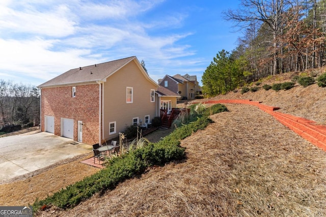 view of side of home featuring a garage and a patio area