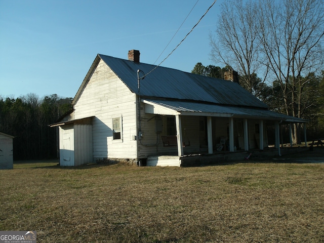 view of side of home featuring a yard and a porch