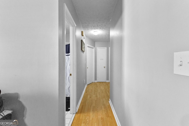 hallway featuring a textured ceiling and light wood-type flooring