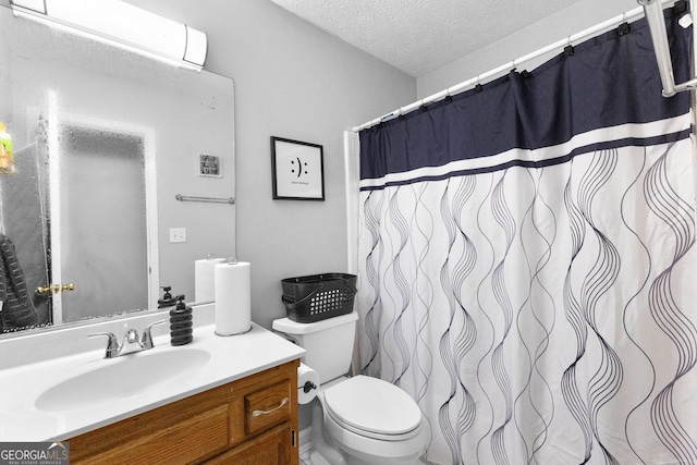 bathroom with vanity, a textured ceiling, and toilet