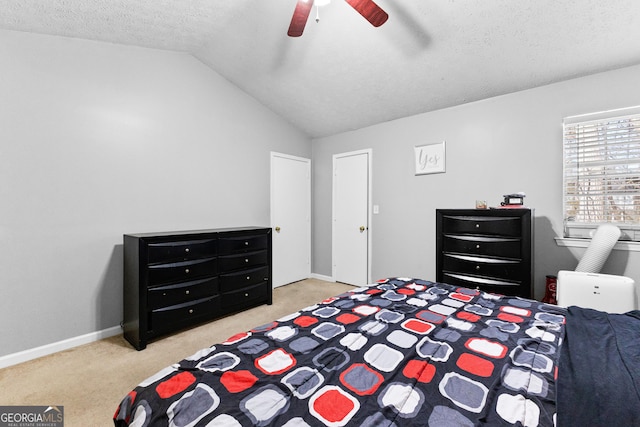 carpeted bedroom featuring ceiling fan, vaulted ceiling, and a textured ceiling