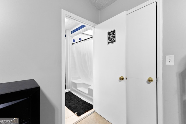 bathroom with shower / bath combination with curtain and a textured ceiling