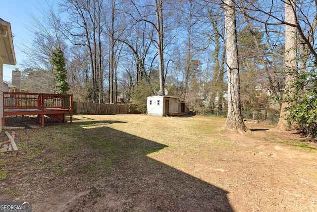 view of yard featuring a deck and a storage unit