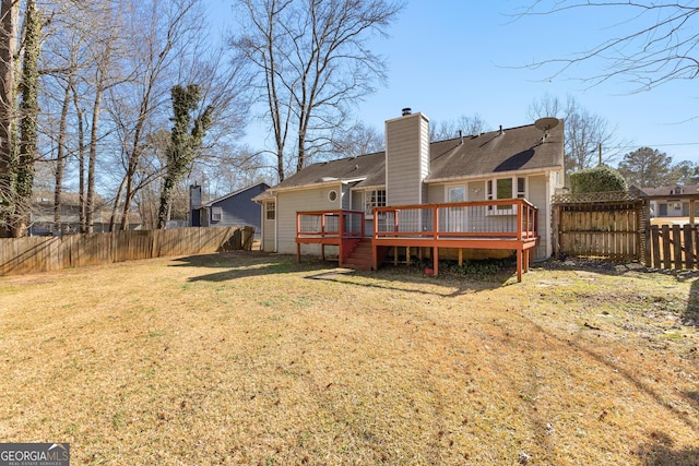 rear view of house featuring a wooden deck and a lawn